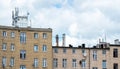 Old multi-story residential building stands under a cloudy sky. A cell tower is installed on the roof, factory power plant Royalty Free Stock Photo