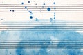 Old music sheet in blue watercolor paint. Blues music concept. Abstract blue watercolor background. Royalty Free Stock Photo