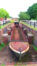 Old narrow boat shell in disused canal lock chamber