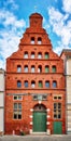 Old narrow gable house facade made of red brick with many small windows in the old town of Wismar