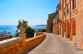 Old narrow street with Ceramic pot with cactus on wall and view on the port and sea in front of Sciacca, Sicily, Italy Royalty Free Stock Photo