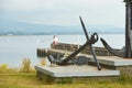 Old naval fortifications and cannons with rusty anchor as landmark and tourist attraction in Wicklow port and village in backgroun