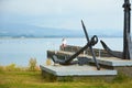 Old naval fortifications and cannons with rusty anchor as landmark and tourist attraction in Wicklow port and village in backgroun