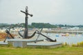 Old naval fortifications and cannons with rusty anchor as landmark and tourist attraction in Wicklow port and village in backgroun