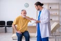 Old neck injured man visiting young male doctor