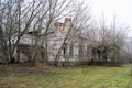 The old, neglected, lordly house and porch among the trees. Texture of old cracked wood painted green.