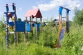 Old neglected playground equipment, overgrown with weeds. Royalty Free Stock Photo