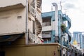 Old neglected white and blue buildings in Little India District in Singapore with spiral staircases and worn out paint