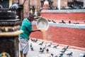 Old Nepalese man feeding pigeons