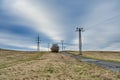 Electric power grid frame pylons and transmission towers along rural road in grasslands of Czechia Royalty Free Stock Photo