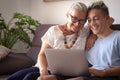 Old and new millenial generation sharing same laptop with fun. Grandmother and grandson smile happy, concept of love and