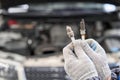 Old and new spark plugs. Comparing spark plugs the maintenance of the engine, on the hands of a mechanic. Royalty Free Stock Photo