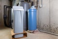 Old and new water softener tanks in a utility room