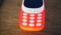 Old nokia 3310 keypad phone isolated on wooden table background. Old Classic mobile cell phone with small screen. Nokia branded Royalty Free Stock Photo