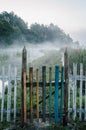 Old non-ferrous fence along the path through the river. swamp. Fog, grass, trees against the backdrop of lakes and nature. Fishing