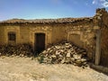 An old North African stone tile-roofed house with a pile of building stones in the front Old Algerian city of Ksar El Boukhari Royalty Free Stock Photo