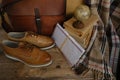 old nostalgic sentimental things, letters, stack of books, globe, shoes, vintage leather military satchel on table, checkered