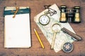 Old notebook, compass, map, vintage binoculars, pencil, pocket watches, knife, magnifying glass on wooden background Royalty Free Stock Photo