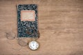 Old notebook, retro eye glasses and vintage pocket watches on oak textured wooden table background Royalty Free Stock Photo