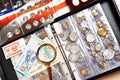 Old numismatic coins and notes with magnifying glass Royalty Free Stock Photo