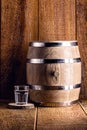 Old oak barrel and glass of high quality distilled alcohol. Brazilian silver cachaÃÂ§a, called pinga, vodka, white rum, liqueur, Royalty Free Stock Photo