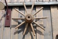 Old oak wheel from a rustic cart hanging on the wall of a barn