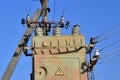 Old and obsolete electrical transformer against the background of a cloudless blue sky. Device for distribution of supply of high Royalty Free Stock Photo