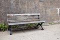 Old obsolete wooden bench on the sidewalk