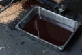 Old oil tray that was removed from the automobile. Old black oil lubrication engine vehicle motor car used leak or drip spill from