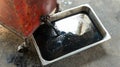 Old oil tray that was removed from the automobile. Old black oil lubrication engine vehicle motor car used leak or drip spill from