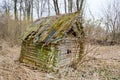 Old old dilapidated small wooden abandoned ruined, rickety broken village house of beams, logs and sticks covered with moss in the