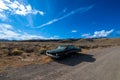 Old Oldsmobile 88 Car in Nevada Desert with blue sky on the horizon in the summer