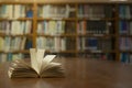 Old open book on the table a bookshelf background for academic education learning concept Royalty Free Stock Photo