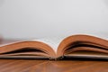 Old open book on a wooden table. White background. Copy space