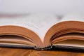 Old open book on a wooden table. White background. closeup