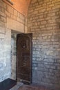 An old open door and a brick wall in a dungeon or in a castle. Royalty Free Stock Photo