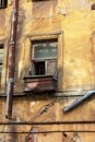 An old open window with a curtain and a wooden box on the windowsill in an abandoned apartment building. close up. Royalty Free Stock Photo