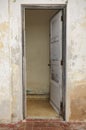 Old opened door in shabby wall facade Royalty Free Stock Photo