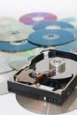 Old opened hard disc on a pile of compact discs Royalty Free Stock Photo