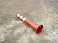 Old orange bollard was hit by car lay down on the concrete road