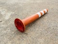 Old orange bollard was hit by car lay down on the concrete road