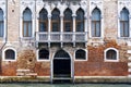 Old orange building with small cracked bricks and beautiful arched window frames in Veneto, Italy