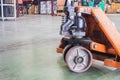 Old orange manual hand pallet trucks. Close up wheel of hydraulic hand pallet truck Royalty Free Stock Photo