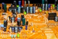 Old orange printed circuit board with multi-colored electronic components