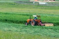 Old orange tractor cutting the grass Royalty Free Stock Photo