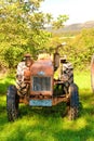 orange rusty antique tractor in field in spain