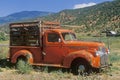 An Old, Orange Truck Rests Abandoned In A Colorado Field, Snowmass, Colorado