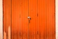 Old orange wooden door with a rusty metal lock texture Royalty Free Stock Photo