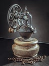 Old original coffee bean original grinder metal shake wheel with hand crank and coffee beans on dark background Royalty Free Stock Photo