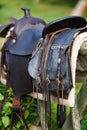 Old ornamental saddle on the wooden fence Royalty Free Stock Photo